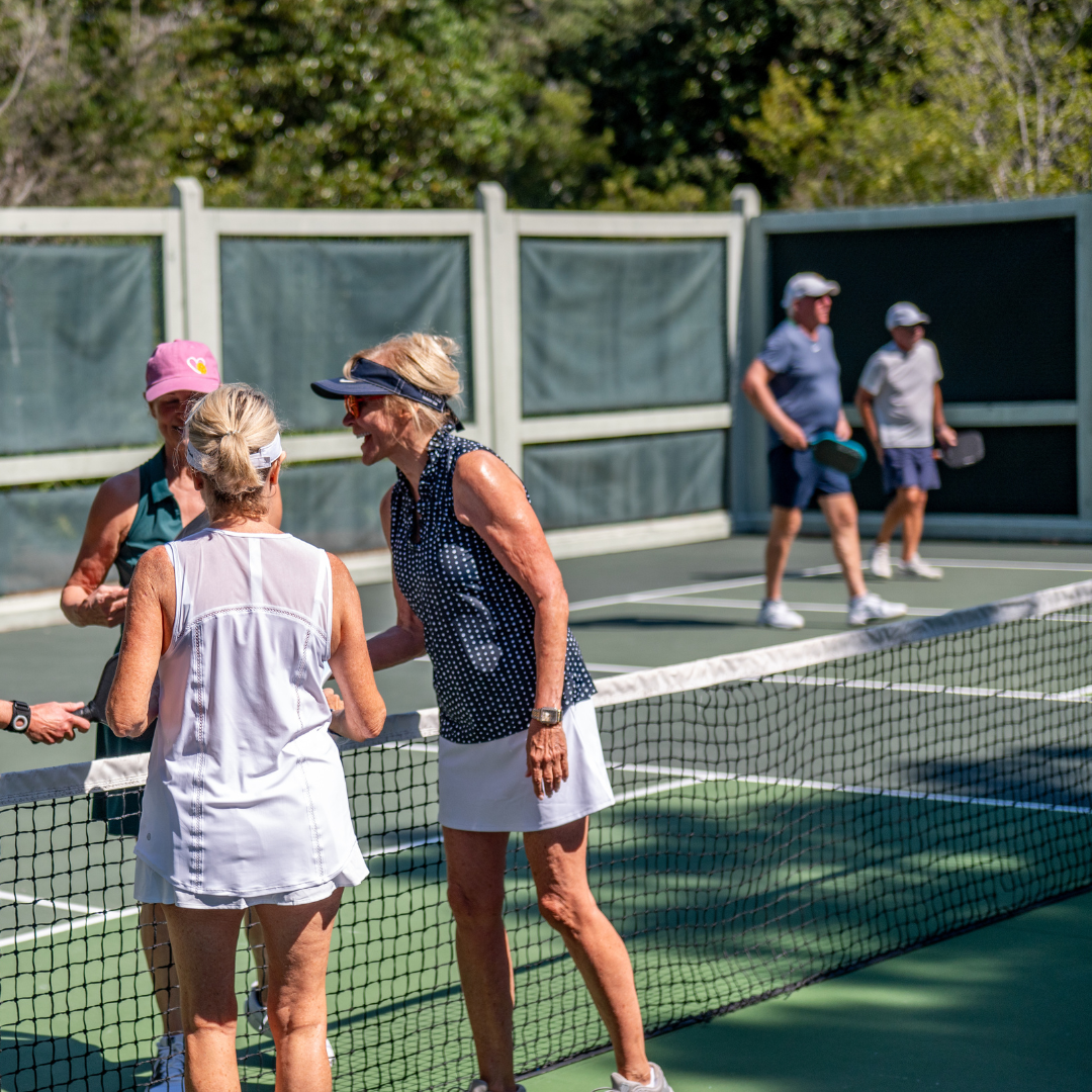 Women gathering on pickleball court
